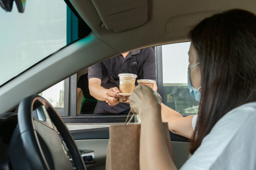 A woman in a car receiving food from drive-thru