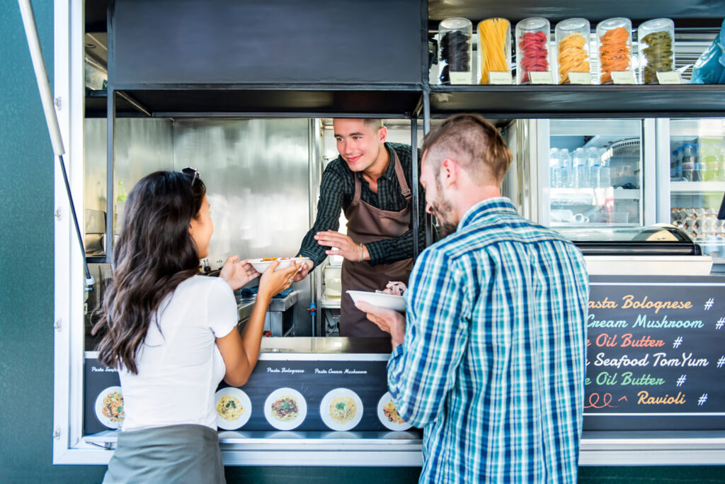 People receiving food from staff in the food-truck