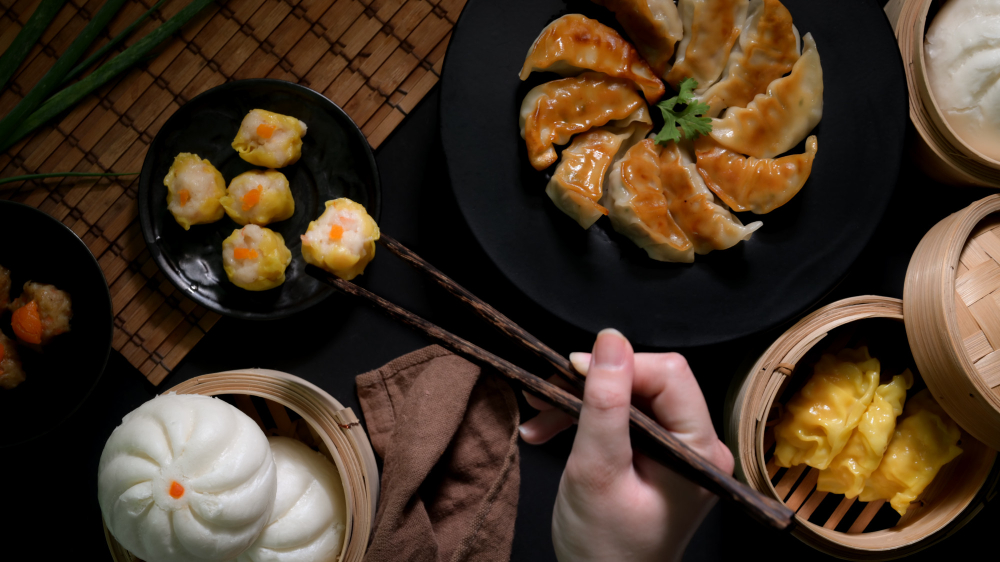 A hand holding a chopstick and want to get dim sum