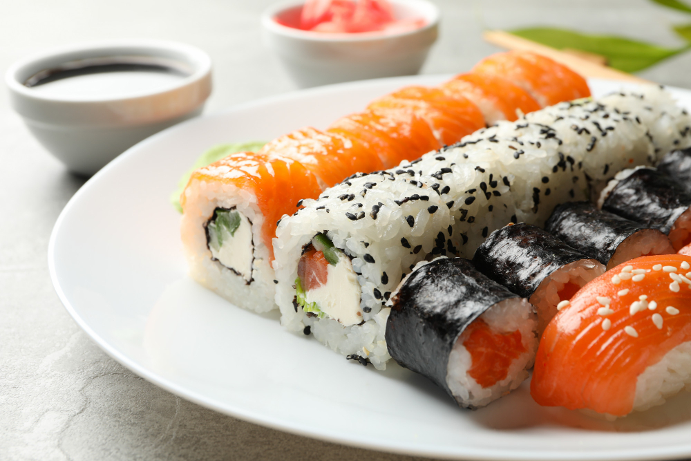 Plate with sushi rolls on gray surface
